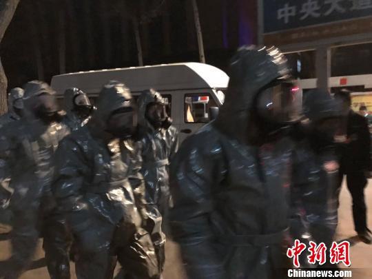 十几名身着防护服的人员头戴面具进入事发地。　胡健 摄